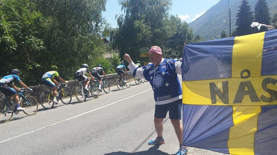 Thomas med Nås-flaggan vid vägkanten när Tour de France-klungan passerar